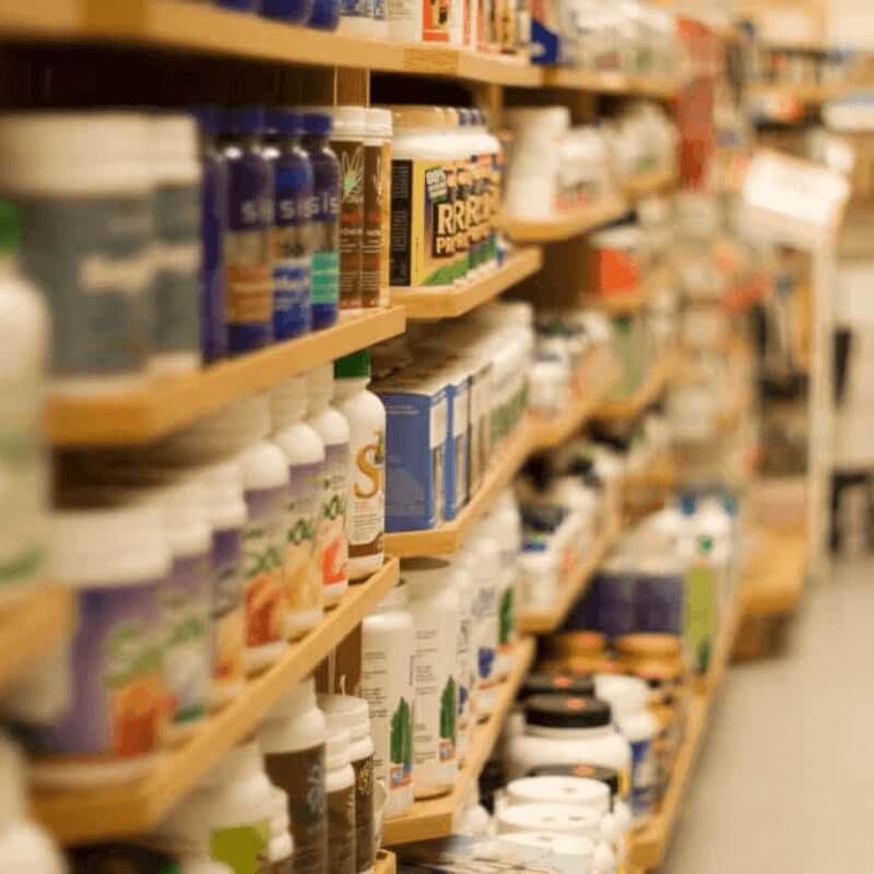 The image shows shelves stocked with bottles and containers, like a store aisle.